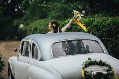 Retro araba içinde şık mutlu gelin. Duygusal an. 