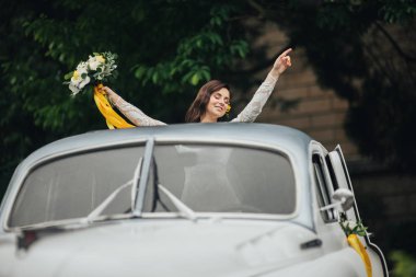 Retro araba içinde şık mutlu gelin. Duygusal an. 