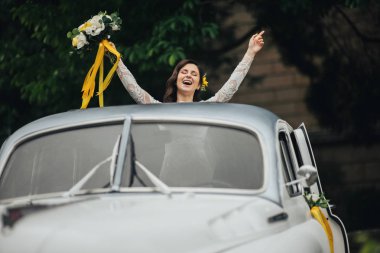 Retro araba içinde şık mutlu gelin. Duygusal an. 