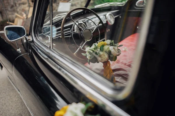 Wedding bouquet on vintage wedding car