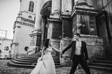 Eski şehir caddesinde yürüyen neşeli yeni evli çift