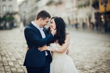 Mutlu damat ve gelin boş şehir sokakta yürüyüş 