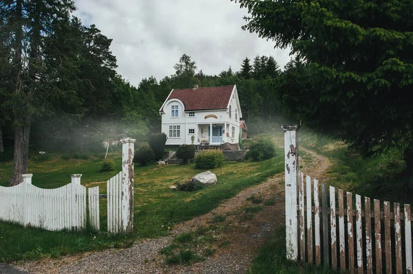 Casa na floresta. Casa Branca no nevoeiro da manhã. Velha casa mística no nevoeiro entre as árvores . — Fotografia de Stock