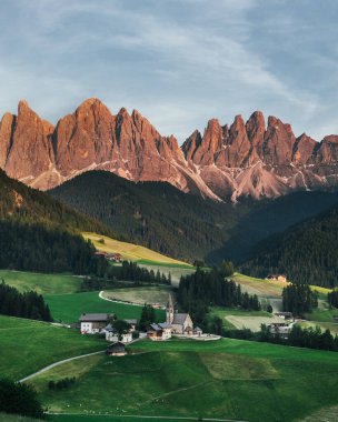 Alplerdeki güzel köy. Dolomitler üzerine Santa Magdalen. İtalya 'da dağlarda gün batımı. Dağların kırmızı tepeleri.