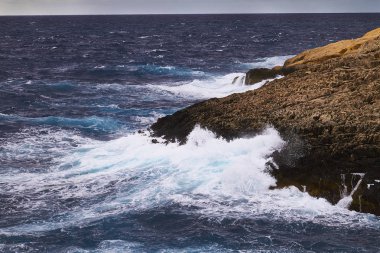Bulutlu bir günde büyük dalgalar çarpar. Kemmuna Adası
