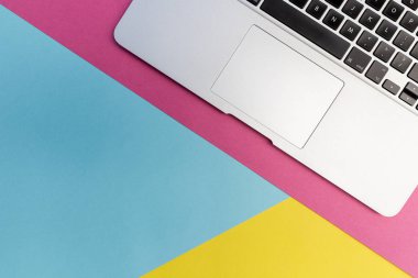 Laptop klavye parlak pembe, sarı ve mavi arka plan üzerinde