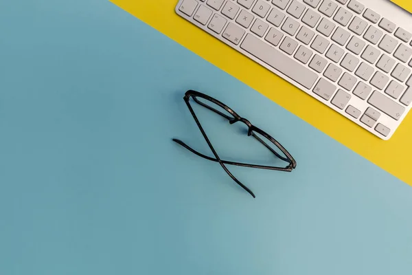 Computer Keyboard Eyeglasses Bright Yellow Blue Background — Stock Photo, Image