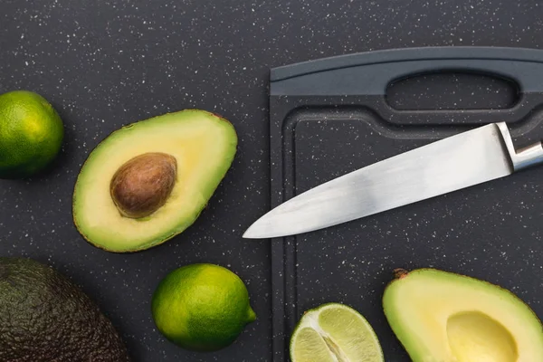 Avocado Helften Verse Limoenen Hakken Bord Met Mes — Stockfoto