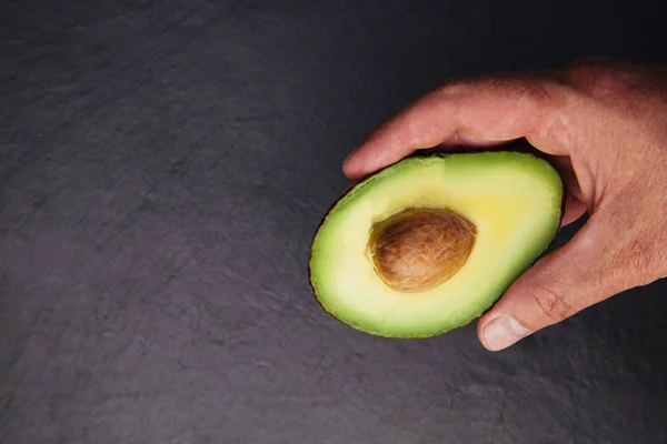 Aguacate Mano Medio Sobre Fondo Oscuro —  Fotos de Stock