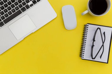 Dizüstü bilgisayar fare ve parlak sarı arka plan üstünde defter