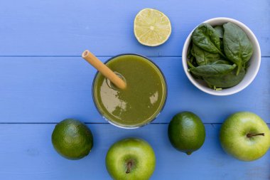 Mavi Masa arka plan üzerinde saman sağlıklı yeşil smoothie içkiyle