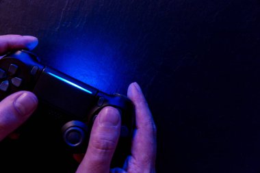 Işıkları ile gece video oyun denetleyicisi ile oynarken adam