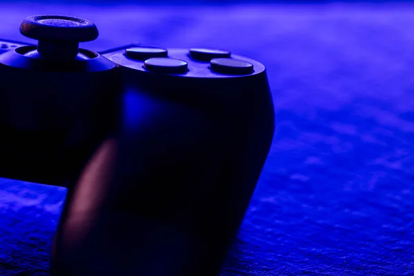 Close view of video game controller at night with neon blue lights