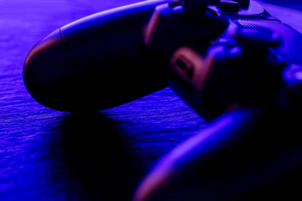 Close view of video game controller at night with neon blue lights