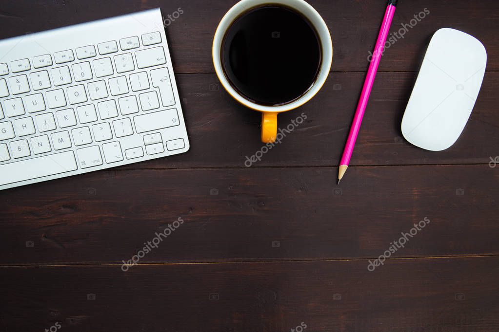Computer keyboard, coffee cup, pencil and mouse on wood office desk workspace