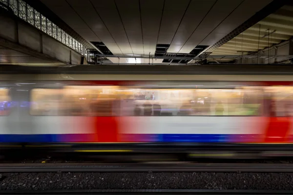Speeding train arriving at platform on London underground tube station