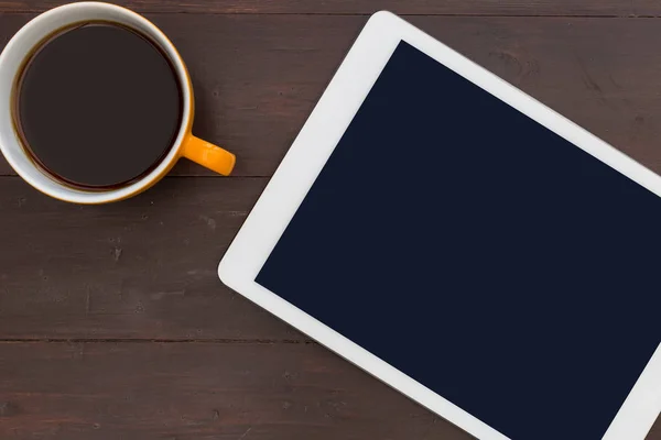 Kahve fincanı ahşap ofis resepsiyon masasında beyaz tablet bilgisayarınızla