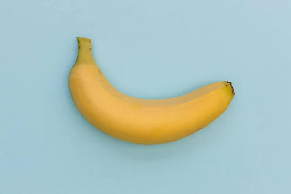 Gul Banan Isolerad Blå Färg Bakgrund Minimal Frukt Mat Ovanifrån — Stockfoto