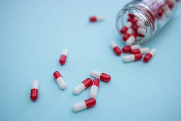 Капсулы с лекарствами на фоне синего цвета — стоковое фото