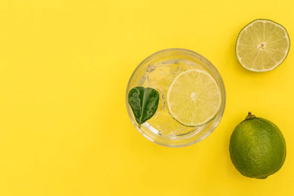 Bebida de cóctel gin tonic en vaso sobre fondo amarillo veraniego — Foto de Stock