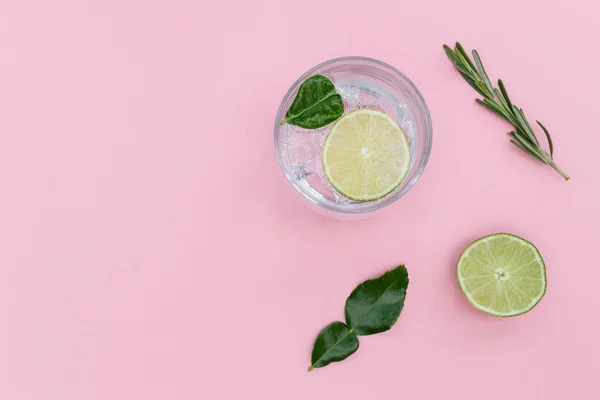 Gin tonic cocktaildrink i glas på sommaren rosa bakgrund — Stockfoto