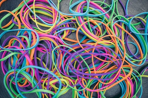 Colorful rubber elastic bands on dark background