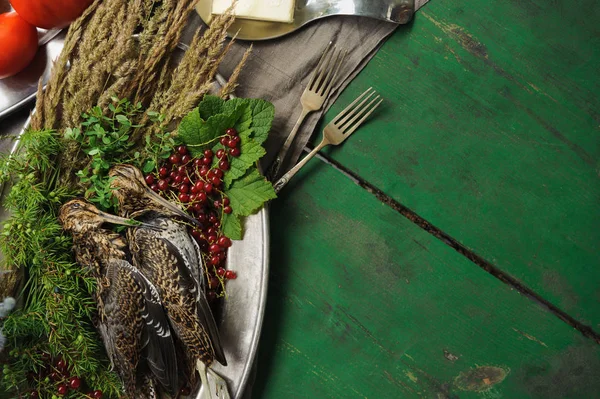 Wild hunting fowls in cooking. Two snipe or woodcock lie on metal dish. Wildfowl hunting.