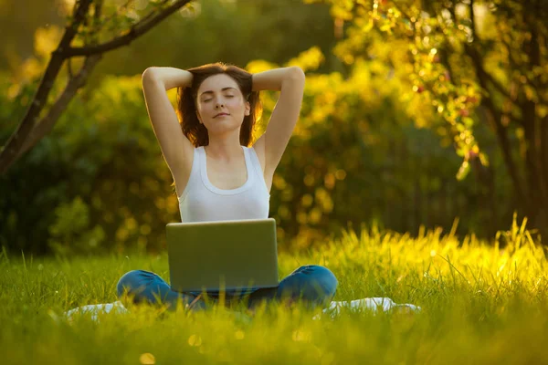 在美丽的公园与膝上型电脑的妇女沉思莲花姿势 — 图库照片