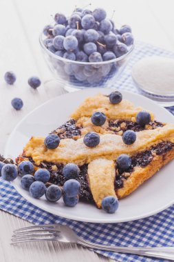 Beyaz ahşap bir masa üzerinde yaban mersini ile lezzetli ev yapımı pasta