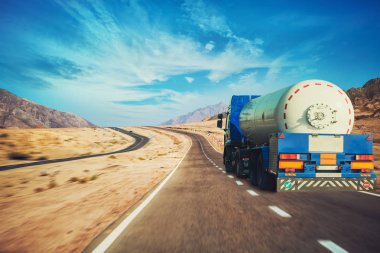 Beyaz tanker çöl Dağ karayolu çevresinde asfalt yol boyunca sürüş.