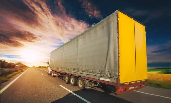 Ciężarówka Drodze Jazdy Wzdłuż Drogi Asfaltowej Całym Polu Żółty Kwitnienia — Zdjęcie stockowe