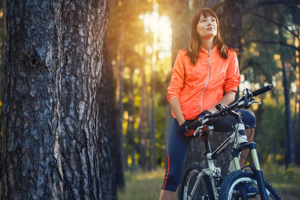 cute woman cyclist cycling mountain bike on Pine forest trail