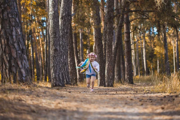 Uma Menina Uma Grinalda Com Fitas Está Correndo Feliz Através — Fotografia de Stock