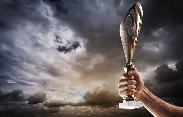 Altın Fincan Kasvetli Fırtınalı Gökyüzü Karşı Elini Tutuyor Bir Yarışmada — Stok fotoğraf