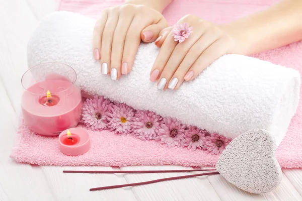 美丽的粉红修指甲与蜡烛 菊花花和毛巾在白色的木桌上 — 图库照片