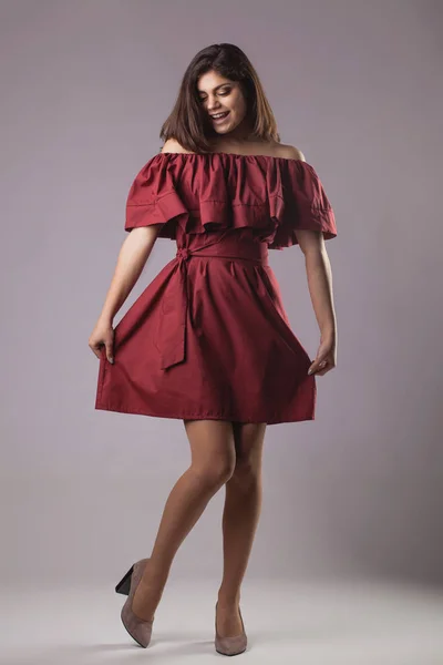 Junge Brünette Frau Rotem Kleid Posiert Auf Grauem Hintergrund — Stockfoto