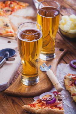 iki bardak sıcak pizza eski ahşap masa ile hafif bira. Önemli bir akşam yemeği