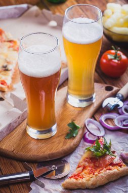 iki bardak sıcak pizza eski ahşap masa ile hafif bira. Önemli bir akşam yemeği