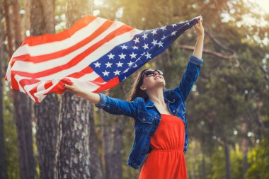 Ulusal Amerikan bayrağı açık havada ile mutlu gülümseyen genç kadın. Bağımsızlık günü, 4 Temmuz