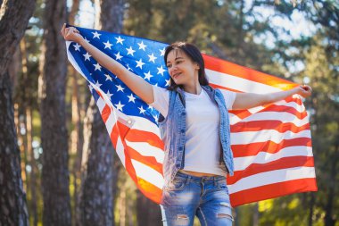 Ulusal Amerikan bayrağı açık havada ile mutlu gülümseyen genç kadın. Bağımsızlık günü, 4 Temmuz