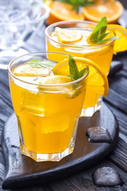 Turuncu buz ve siyah ahşap bir masa üzerinde taze nane kokteyli. canlandırıcı yaz içeceği