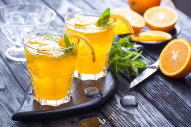 Turuncu buz ve siyah ahşap bir masa üzerinde taze nane kokteyli. canlandırıcı yaz içeceği