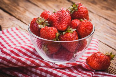 Bir kase çilek. Ahşap masa üzerinde taze güzel çilek.