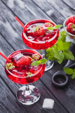 çilek buz ve siyah ahşap bir masa üzerinde taze nane kokteyli. canlandırıcı yaz içeceği
