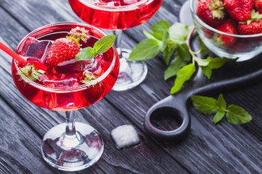 çilek buz ve siyah ahşap bir masa üzerinde taze nane kokteyli. canlandırıcı yaz içeceği