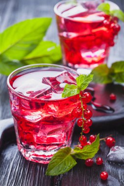 Frenk üzümü buz ve siyah ahşap bir masa üzerinde taze nane kokteyli. canlandırıcı yaz içeceği