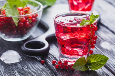 Frenk üzümü buz ve siyah ahşap bir masa üzerinde taze nane kokteyli. canlandırıcı yaz içeceği