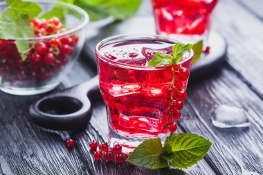 Frenk üzümü buz ve siyah ahşap bir masa üzerinde taze nane kokteyli. canlandırıcı yaz içeceği