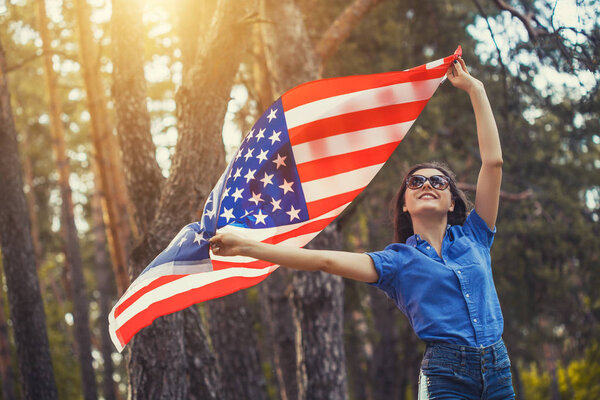 happy smiling young woman with national american flag outdoors. Independence Day, 4th July