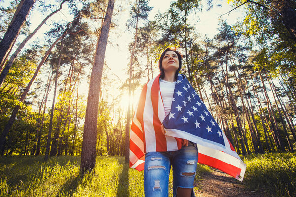 happy smiling young woman with national american flag outdoors. Independence Day, 4th July